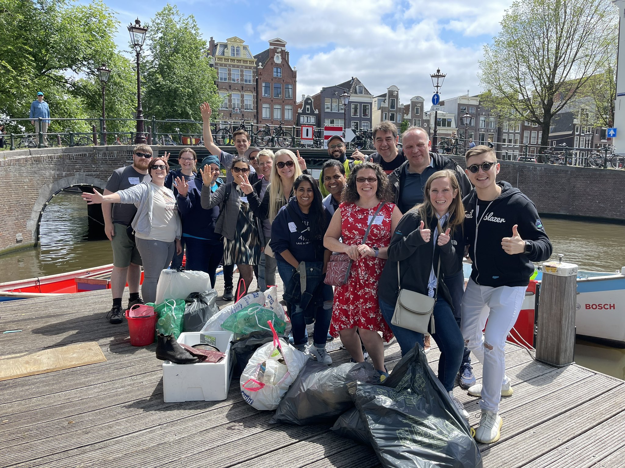 Various people active in the Salesforce ecosystem surrounded by bags of rubbish that they have collected from Amsterdam's canals